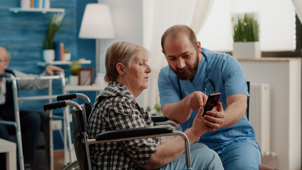 Aged care worker assisting an older woman in a wheelchair during Aged Care Employee Day