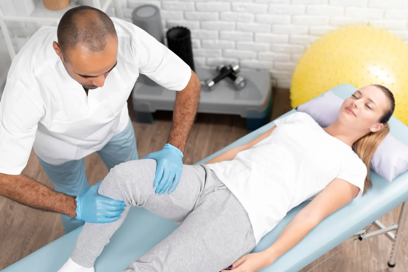 Healthcare professional assessing a patient’s knee during a treatment appointment