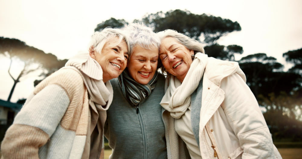 Older women standing together outdoors, sharing connection and friendship on International Day of Older Persons.