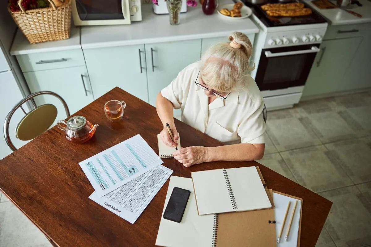 Organising Important Life Information Older woman organising important life documents and planning information at home