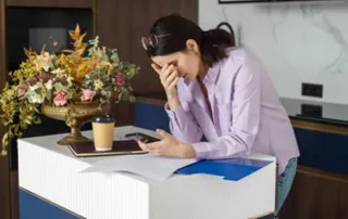 Woman reviewing important documents while dealing with the practical burden of grief.