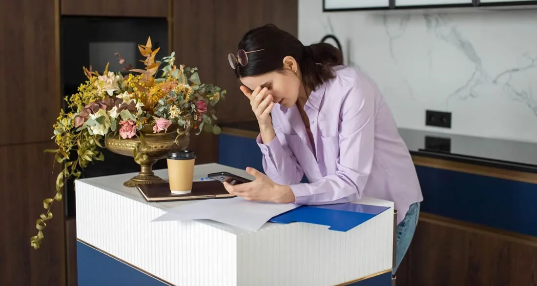 Woman reviewing important documents while dealing with the practical burden of grief.