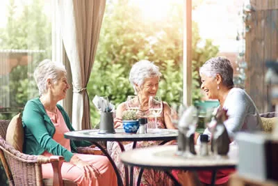 Older friends enjoying a meal and conversation together.