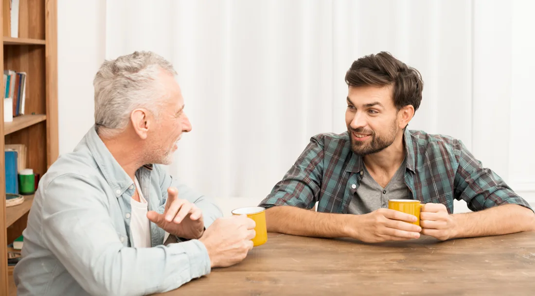 Younger man listening to an older family member during a supportive conversation