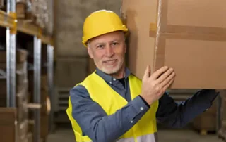 Man carrying box carefully to ensure safety in the workplace
