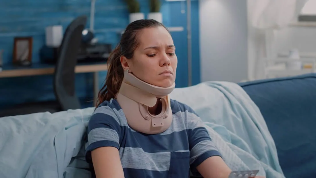 Woman recovering at home with a neck brace after an injury