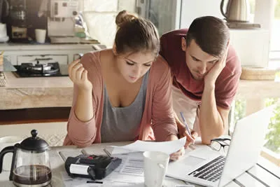 Couple reviewing household bills and expenses following an unexpected interruption to work.
