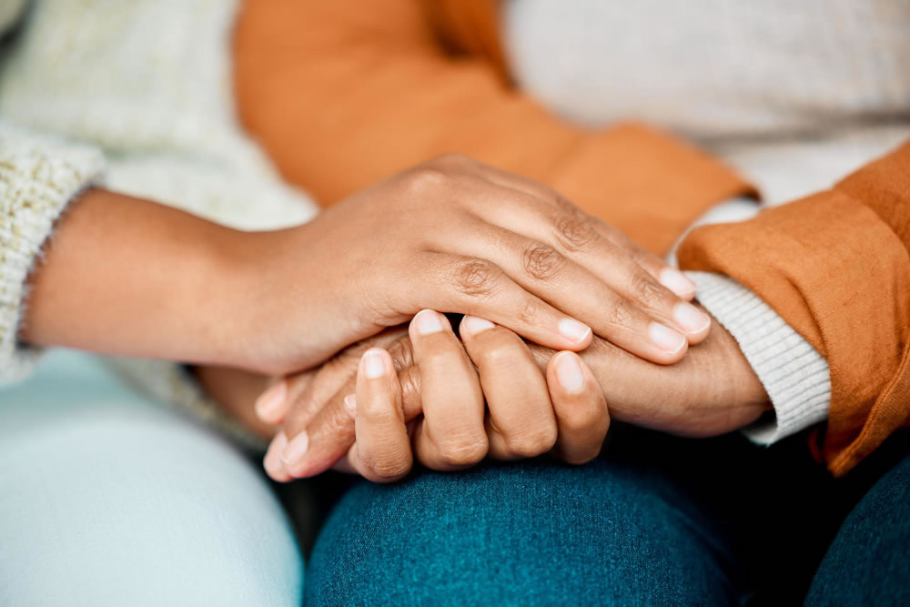 Hands holding in a moment of comfort and support.