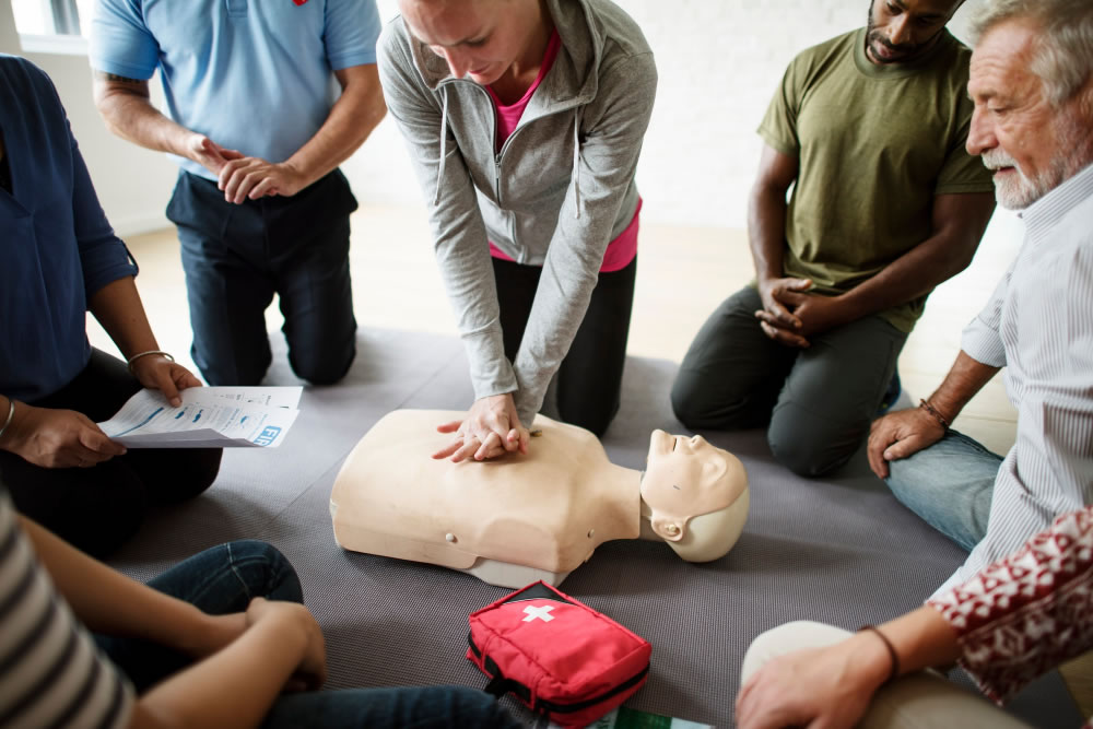 Community members practising CPR and AED use during a first aid training session for World Restart a Heart Day.